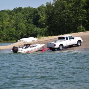 truck pulls a boat out of lake on trailer